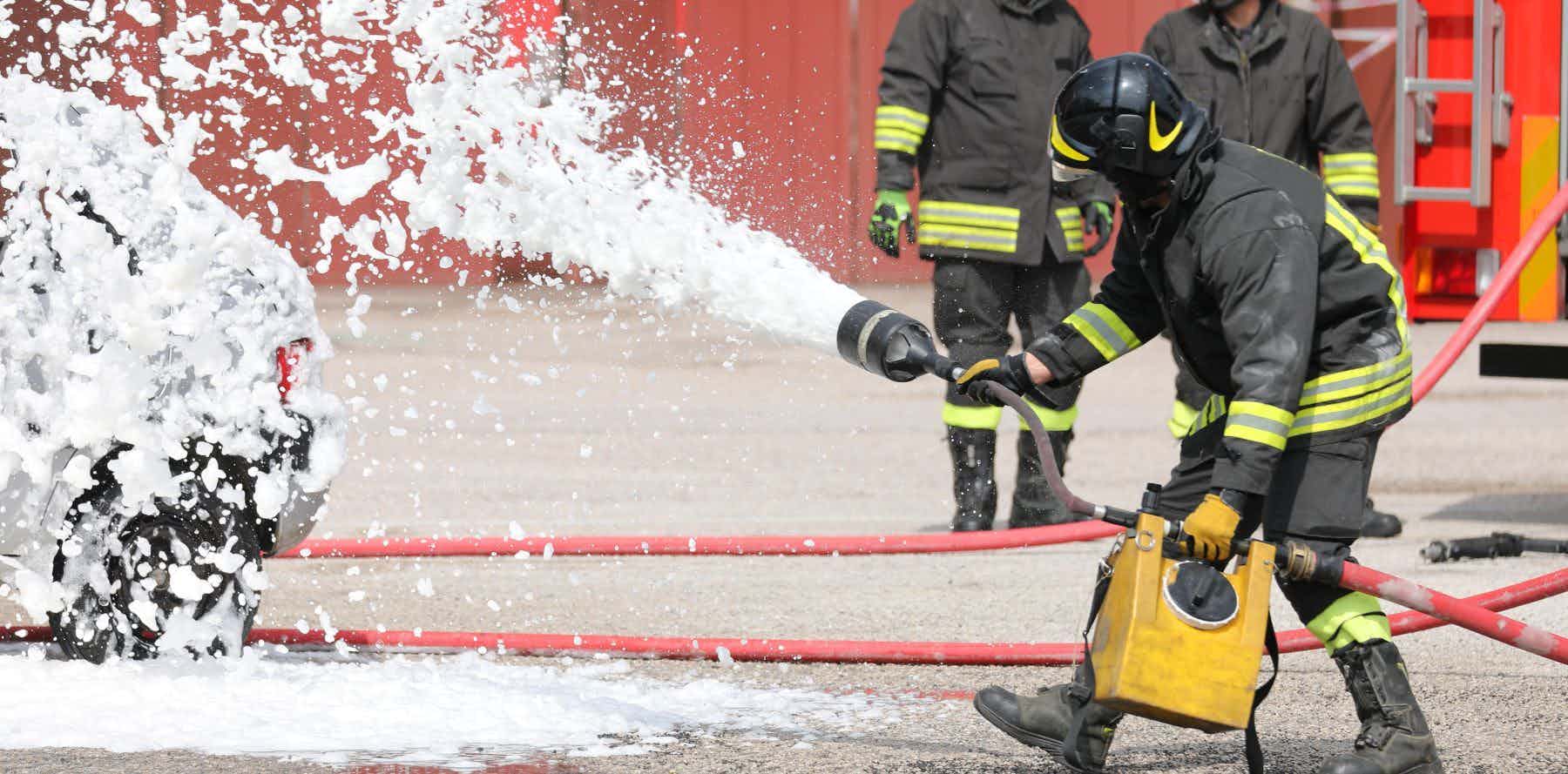 Firefighter using foam to extinguish fire